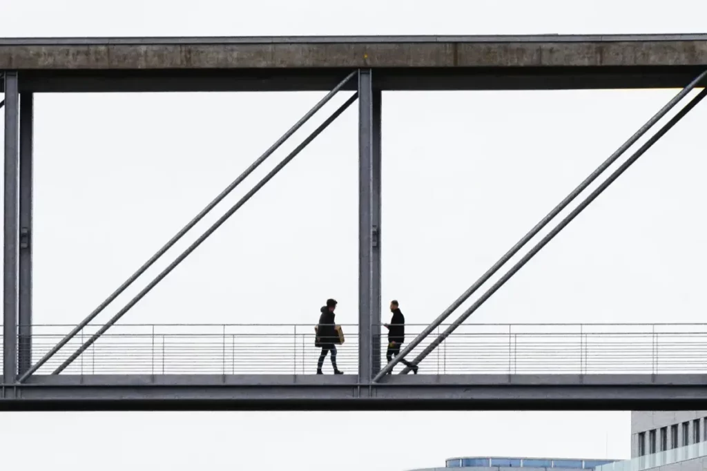 2 individus se croisant sur une passerelle symbolisant le turn over